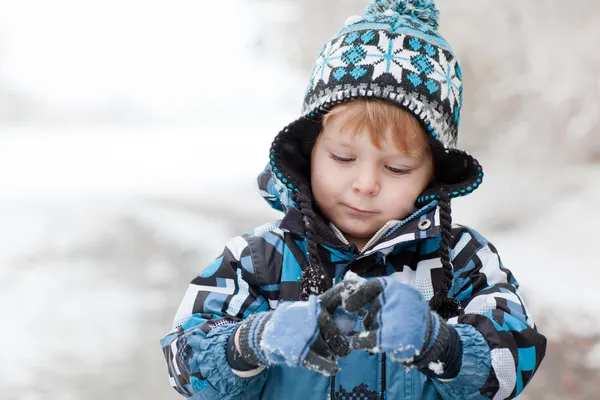 Adorable niño que se divierte con la nieve en el día de invierno — Foto de Stock