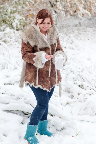 Молодая женщина веселится со снегом в зимний день — стоковое фото