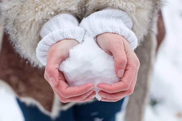 Mãos de mulher com coração de neve — Fotografia de Stock