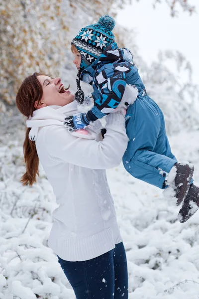 Mor och barn pojke att ha kul med snö på vinterdag — Stockfoto