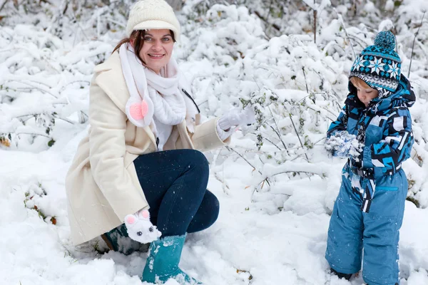 Mor och barn pojke att ha kul med snö på vinterdag — Stockfoto