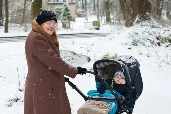 Бабушка гуляет с маленьким мальчиком зимой — стоковое фото