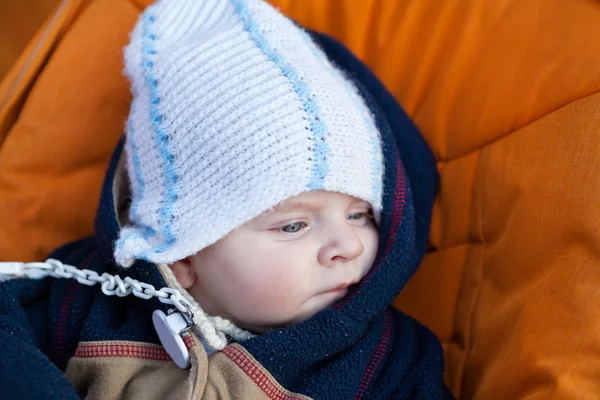 Lovely baby boy outdoor in orange stroller — Stock Photo, Image