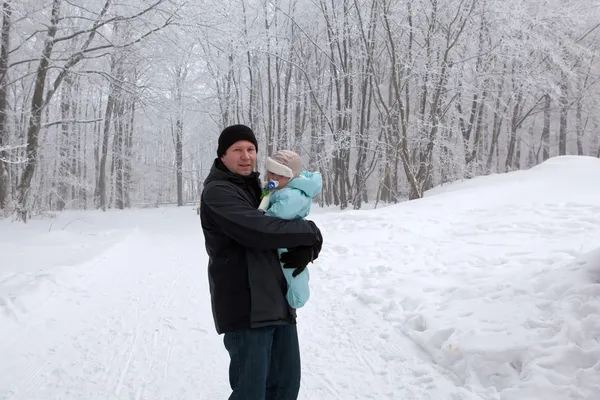 Joven padre y bebé en el bosque de invierno — Foto de Stock