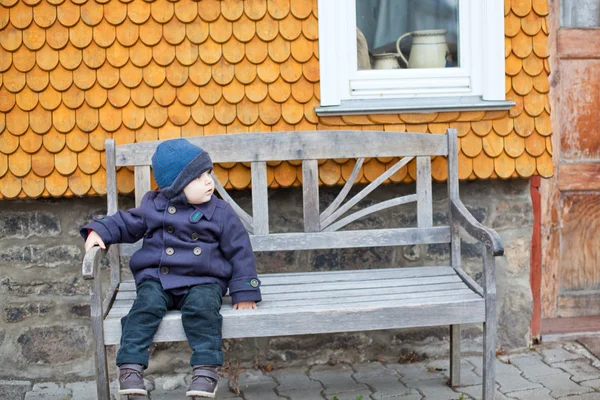 Piccolo bambino ragazzo seduto sulla panchina — Foto Stock
