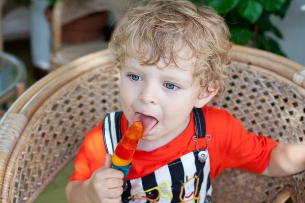 Menino pequeno comendo sorvete colorido — Fotografia de Stock