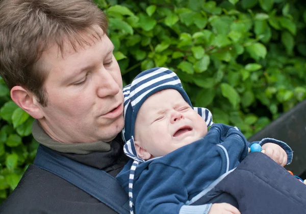 공원에 슬링에 아들을 운반 하는 젊은 아버지 — 스톡 사진