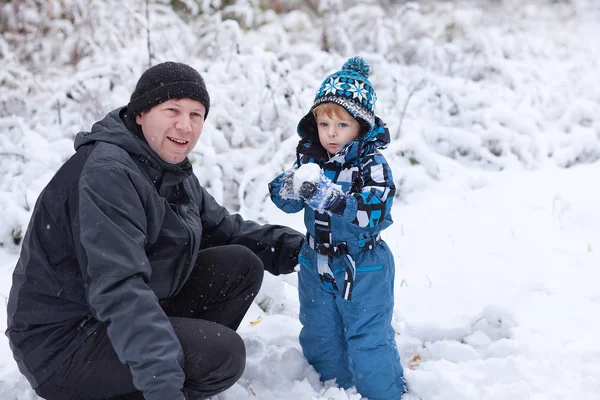 Vater und Kleinkind amüsieren sich am Wintertag mit Schnee — Stockfoto