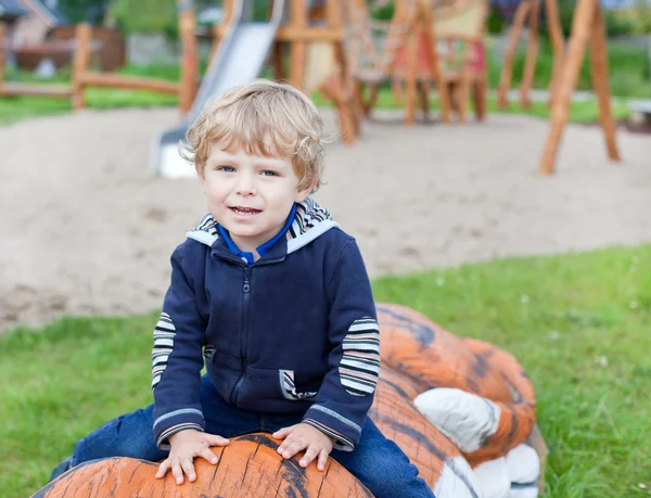 Маленький мальчик сидит на детской площадке — стоковое фото