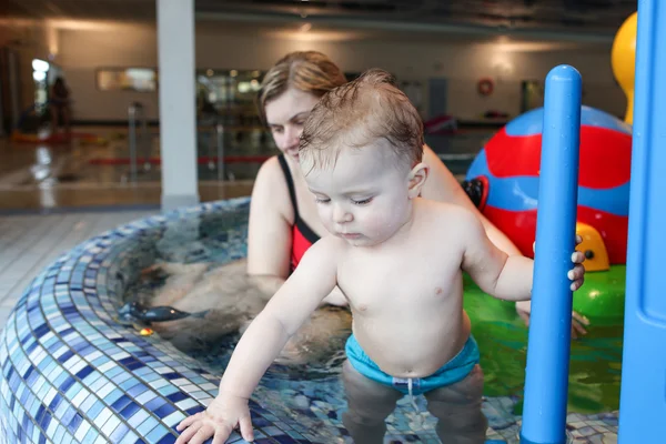 Малыш с голубыми глазами учится плавать — стоковое фото