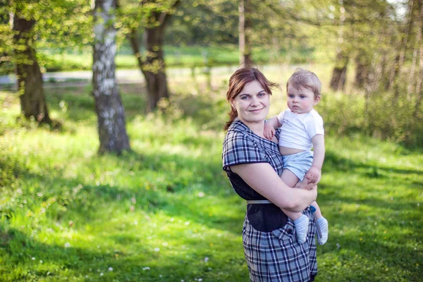 Ung mamma och söta baby boy i sommar skog — Stockfoto