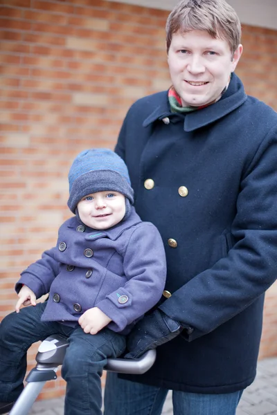 Unga far går med små barn på barnvagn — Stockfoto