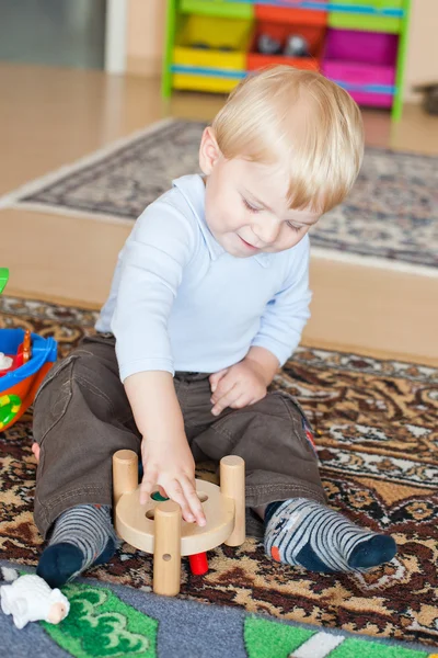 Kleiner Kleinkind Junge spielt mit Holzspielzeug lizenzfreie Stockfotos