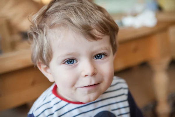 Entzückendes Kleinkind mit blauen Augen drinnen — Stockfoto