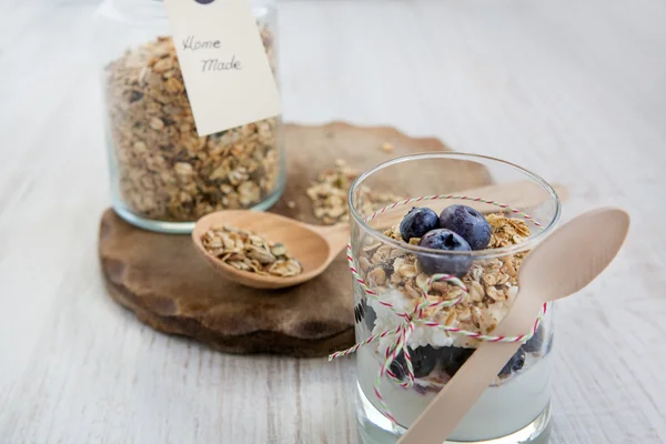 Glass with natural yogurt and jar with home made muesli — Stock Photo, Image