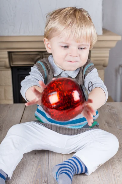 Kleine peuter spelen met rode kerstboom bal — Stockfoto