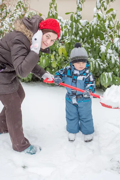 Mujer y niño divirtiéndose con la nieve — Foto de Stock