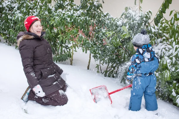 Mor och barn pojke att ha kul med snö på vinterdag — Stockfoto
