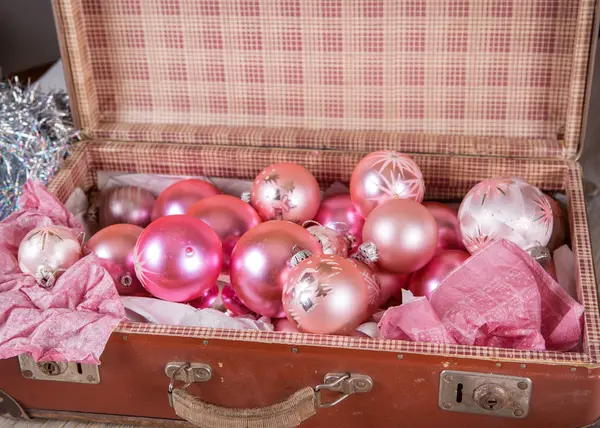 Juguetes de árbol de Navidad rosa antiguo en una maleta antigua — Foto de Stock
