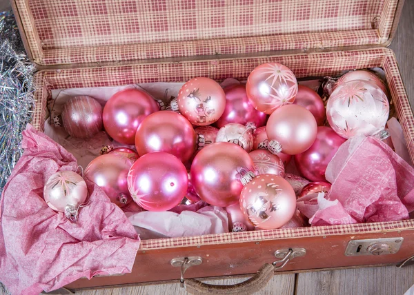 Antigos brinquedos de árvore de Natal rosa em mala antiga — Fotografia de Stock