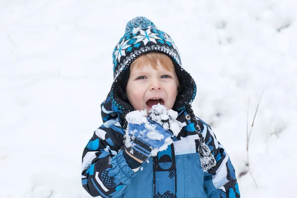 Adorable toddler boy having fun with snow on winter day — Stock Photo, Image