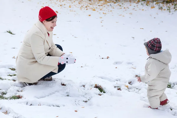 Moeder en peuter jongen met plezier met sneeuw — Stockfoto