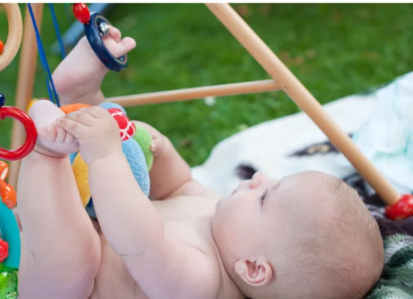 Adorável menino brincando com brinquedos no verão — Fotografia de Stock