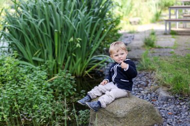 Yaz aylarında göl kenarında küçük yürümeye başlayan çocuk