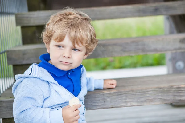 Маленький мальчик сидит на деревянной лестнице — стоковое фото
