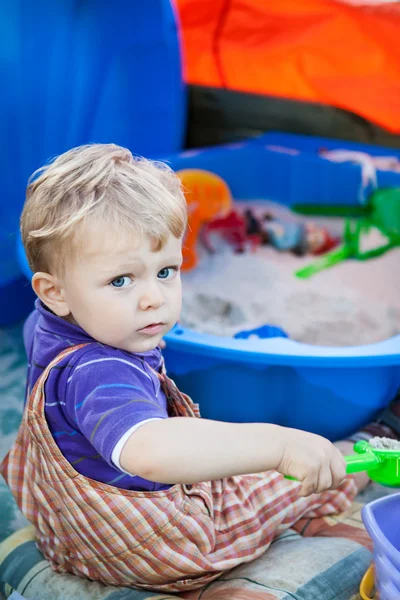 Маленький хлопчик грає з піском та іграшкою — стокове фото