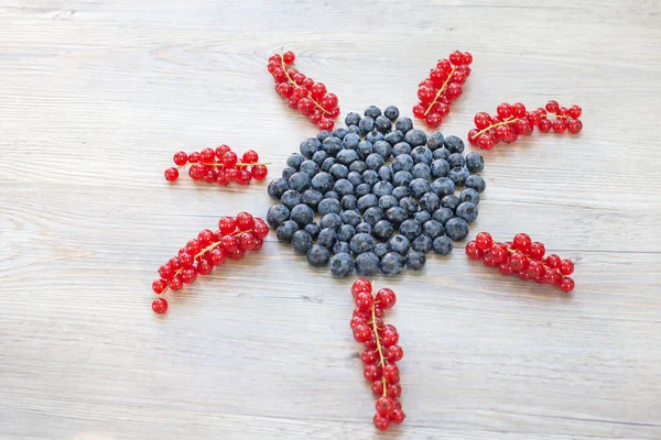 Sun made with red currant berries and blueberries — Stock Photo, Image