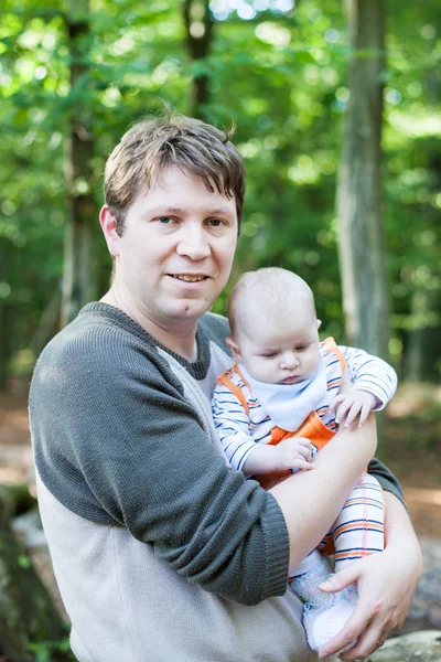 Junger Vater trägt Sohn in Sommerwald — Stockfoto