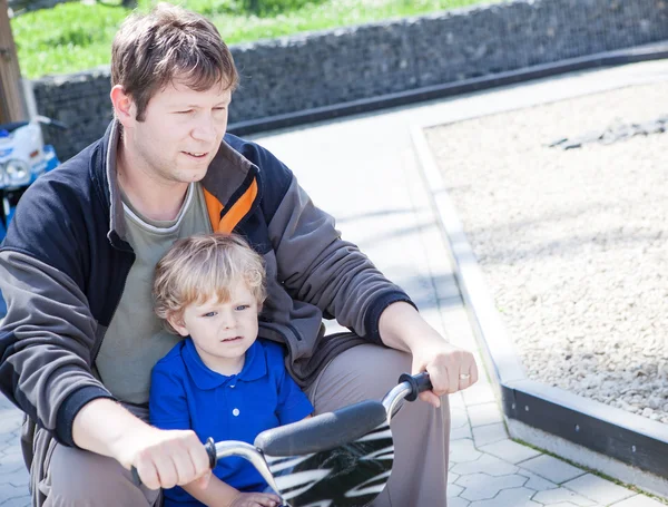 Vater und kleiner Sohn spielen gemeinsam im Freien auf Spielzeugauto — Stockfoto