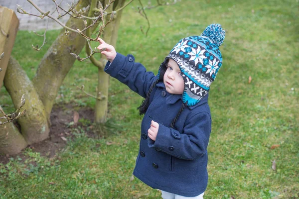 Menino menor de um ano no jardim da primavera — Fotografia de Stock