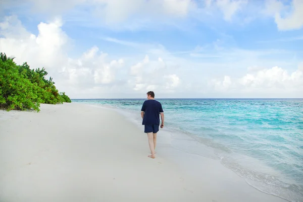 Hombre joven en la playa de arena blanca en Maldivas —  Fotos de Stock