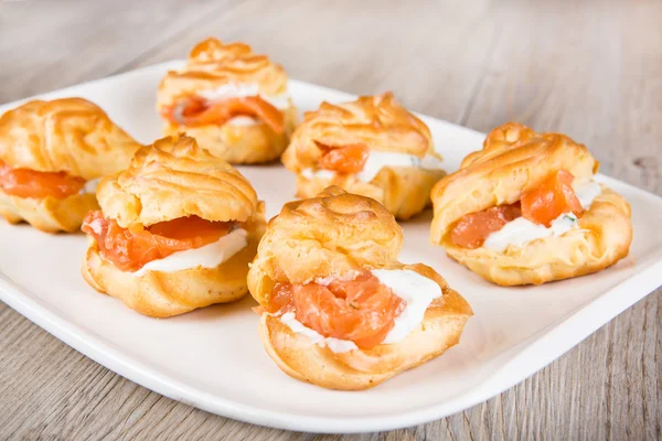 Eclairs en soesjes gevuld met room en zalm — Stockfoto