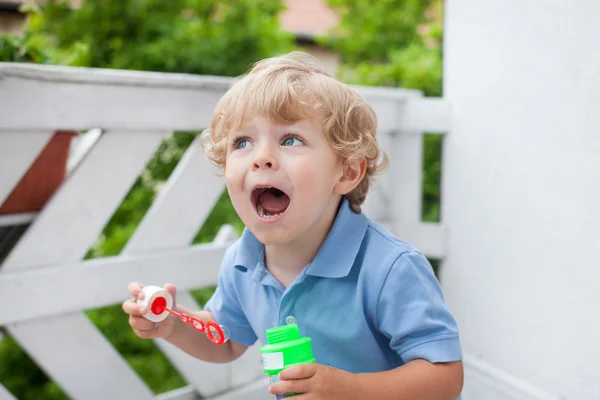 Malý chlapec foukání mýdlové bubliny — Stock fotografie