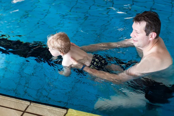 Pai e menino nadando em uma piscina — Fotografia de Stock
