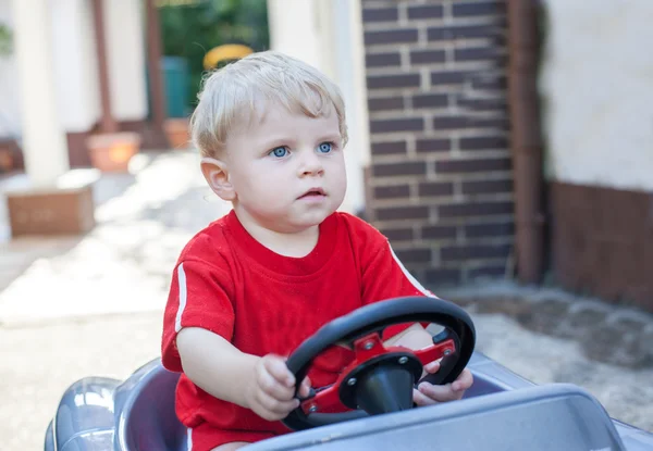 Little todder boy playing with big toy car — Stock Photo, Image