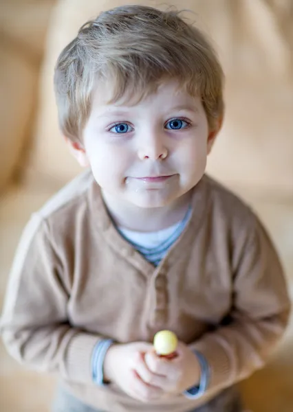 Little happy toddler boy eating lollipop — Stock Photo, Image