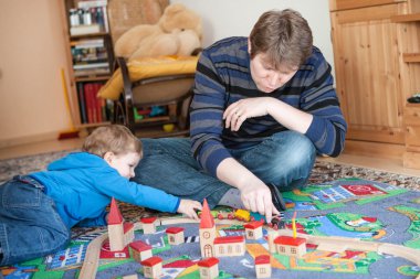 Baba ve küçük ahşap demiryolu oyuncakla oynamak