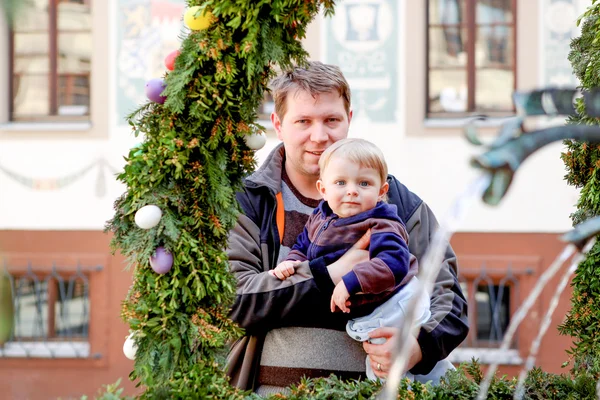 Muž a malý syn poblíž kašny s velikonoční vajíčka — Stock fotografie
