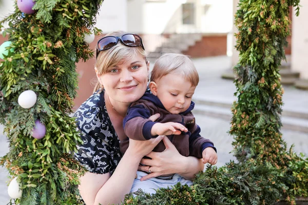 Woman and little son near fountain with Easter eggs — Stock Photo, Image