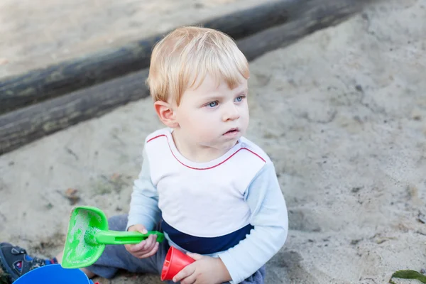 蹒跚学步的小孩玩沙子和玩具 — 图库照片