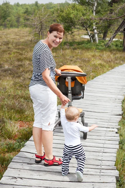 Little baby boy making his first steps with mother — Stock Photo, Image