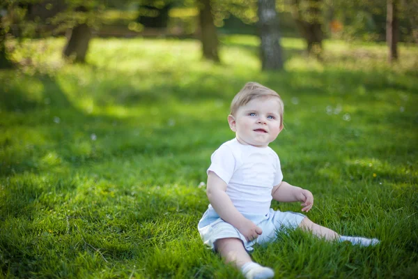 Hermoso niño sobre hierba verde en verano — Foto de Stock