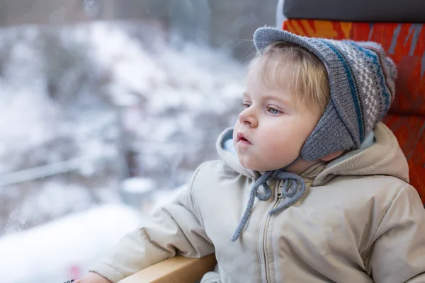 Schattige kleine jongen kijkt uit raam van de trein — Stockfoto