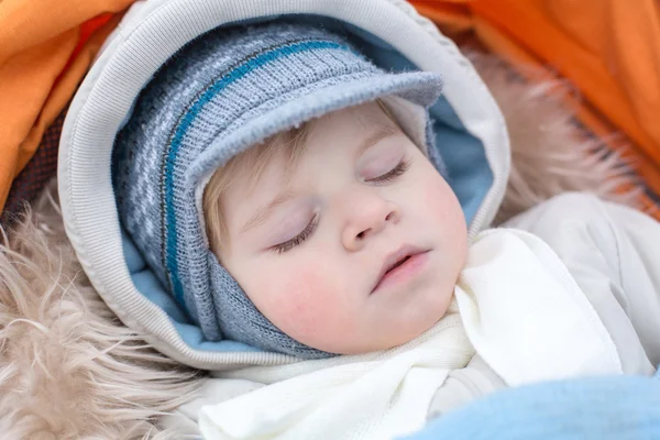 Adorable baby boy in winter clothes sleeping in stroller — Stock Photo, Image