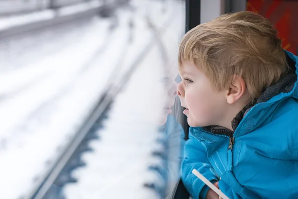 Bonito menino olhando para fora da janela do trem — Fotografia de Stock