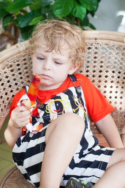 Precioso niño comiendo helado colorido — Foto de Stock